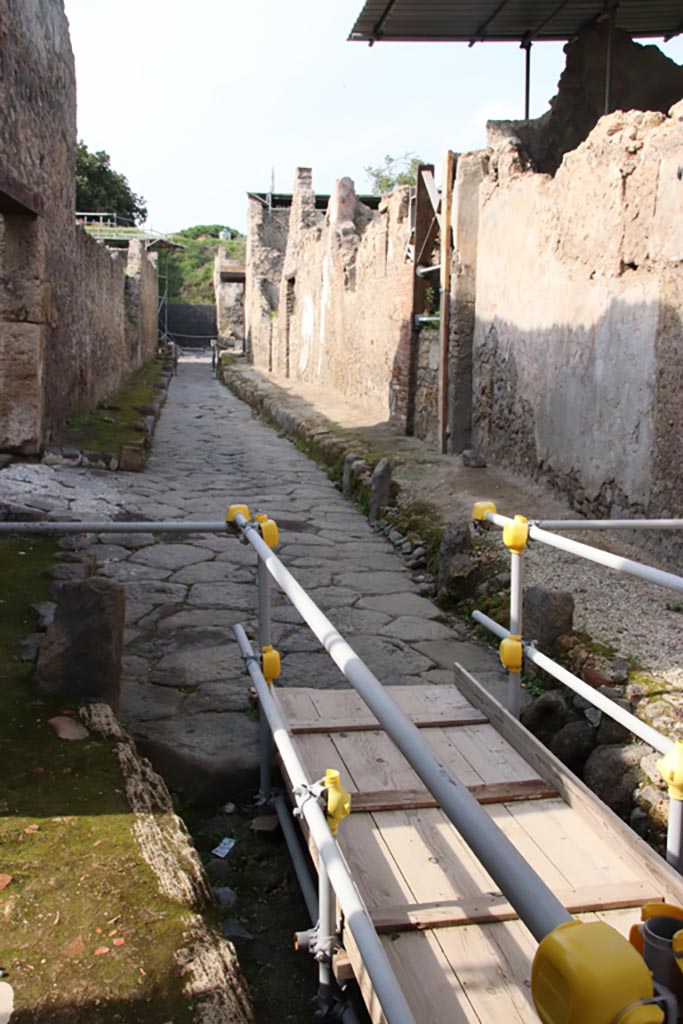 Vicolo dei Balconi, Pompeii. October 2022. 
Looking north along roadway between V.2, on left, and V.3, B5 to B1, on right. Photo courtesy of Klaus Heese.

