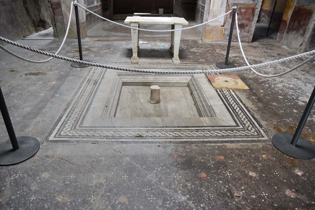 V.4.a Pompeii. March 2018. Atrium room ‘b’, looking east across marble impluvium with twist patterned mosaic edge and marble table.
One of the table legs has a different pattern that the other three.
The atrium floor has a pattern made with different coloured marble pieces.
Foto Annette Haug, ERC Grant 681269 DÉCOR.

