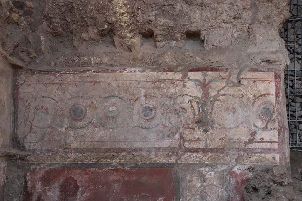 V.7.1 Pompeii, September 2021. Looking towards north wall at west end, detail of painted decoration with girali design. Photo courtesy of Klaus Heese.