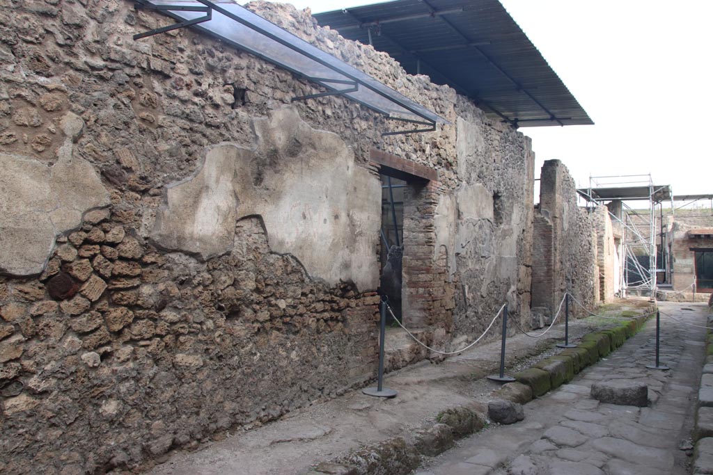 V.7.5, on left and V.7.6, on right, Pompeii. September 2021. 
Entrance doorway with remaining plaster with graffiti, looking west along north side of Vicolo delle Nozze d’Argento.
Photo courtesy of Klaus Heese.

