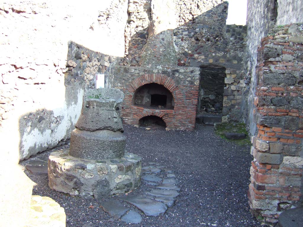 VI.2.6 Pompeii. December 2005. Mill and oven, and doorway to rear room.
According to Boyce, in the north wall of the room behind the oven was a large rectangular niche.
See Boyce G. K., 1937. Corpus of the Lararia of Pompeii. Rome: MAAR 14. (p.44, no.140) 
