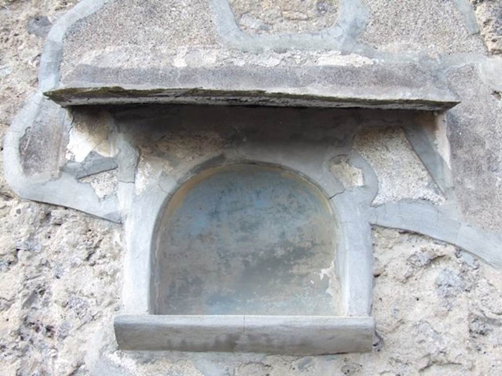 VI.7.3 Pompeii. March 2009. Room 1, niche on north wall of atrium.
According to Boyce, this was a carefully executed arched niche. Below it was a heavy cornice adorned with a frieze of polychrome stucco work projecting from the wall. The niche itself was originally framed by an aedicula façade, of which only the half-columns at the sides remained.
A stucco cornice running around the curve of the arch was also visible to Boyce.  See Boyce G. K., 1937. Corpus of the Lararia of Pompeii. Rome: MAAR 14. (p.47, no.160, and Pl.6,3) 


 
