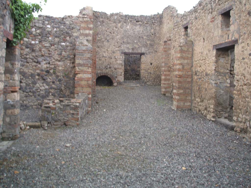 VI.7.15 Pompeii. May 2005. Looking west from entrance across yard towards kitchen area and doorway to dormitory.