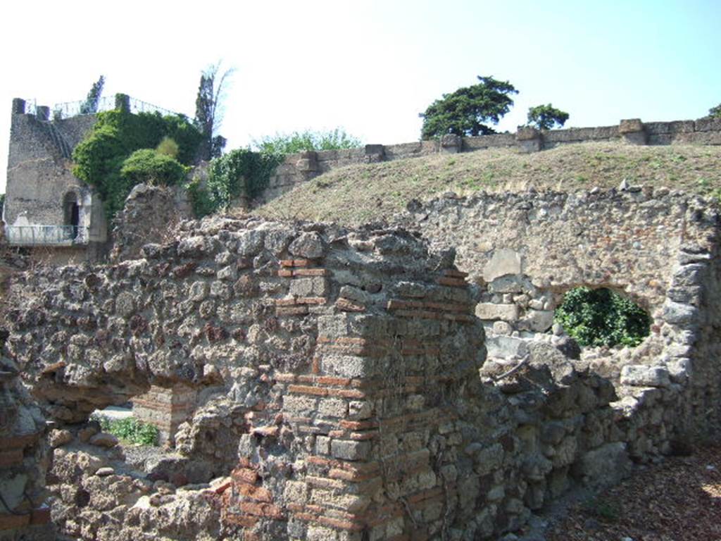 VI.9.14 Pompeii. September 2005. Exterior wall on north side of entrance, with Tower XI and city walls in background.