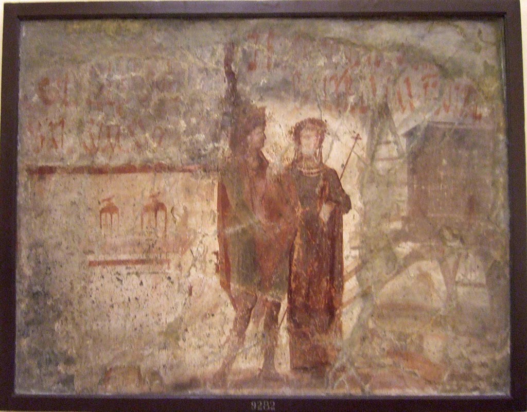 VI.13.6 Pompeii. Painting of two gods with graffiti inscriptions, found on front exterior wall between entrances 6 and 7.  
Now in Naples Archaeological Museum. Inventory number 9282. 
Our thanks to Raffaele Prisciandaro for his help in identifying this object.
See also Fröhlich, T., 1991. Lararien und Fassadenbilder in den Vesuvstädten. Mainz: von Zabern.  (F41, T:17,2)
According to Varone and Stefani, CIL IV 347 and 348 were found here -
See Varone, A. and Stefani, G., 2009. Titulorum Pictorum Pompeianorum, Rome: L’erma di Bretschneider, (p.329)
According to Epigraphik-Datenbank Clauss/Slaby (See www.manfredclauss.de), these read as -

Lollium
[3]i Fuscum aed(ilem) o(ro) v(os) f(aciatis)      [CIL IV 347]

TROOODV[3]RVM
Polybium IIvir(um)     [CIL IV 348]
