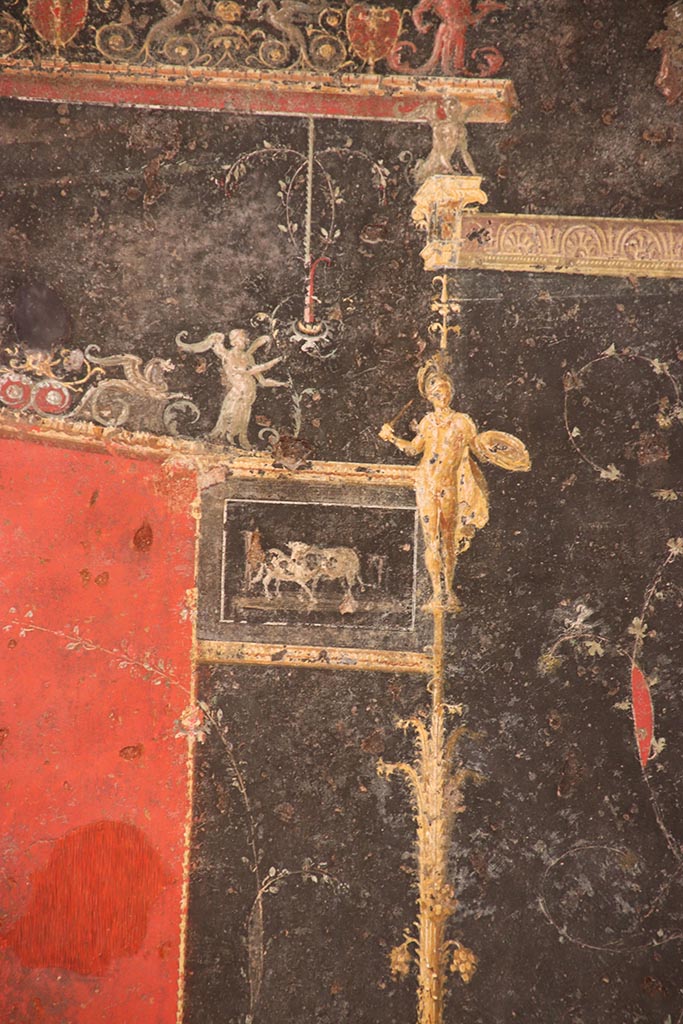 VI.15.1 Pompeii. October 2024. 
Detail from top of left side of black painted panel with candelabra from east end of north wall. 
Photo courtesy of Klaus Heese.
