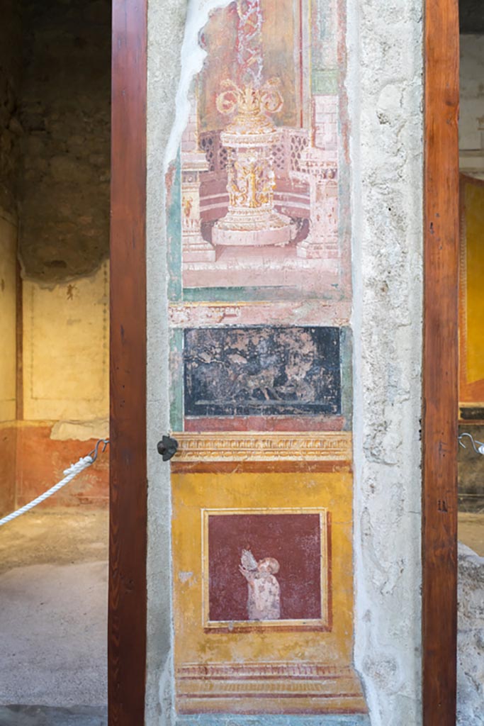 VI.15.1 Pompeii. March 2023. 
Decorative panel on south side of atrium between doorways, with cubiculum f, on left, and ala h, on right.
Photo courtesy of Johannes Eber.

