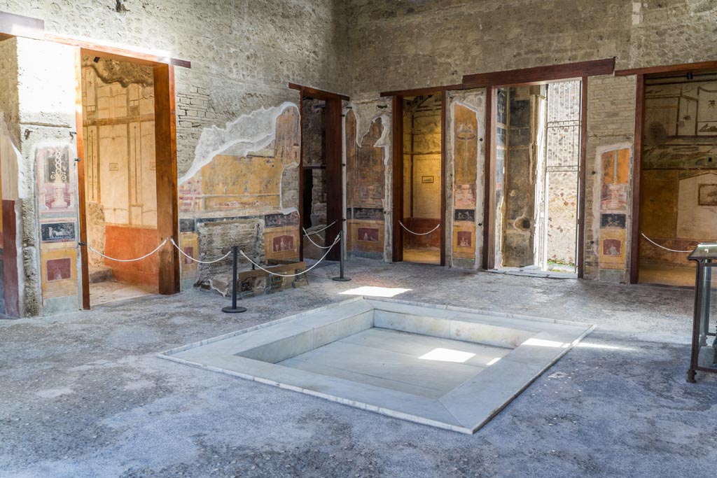 VI.15.1 Pompeii. March 2023. Looking north-east across atrium. 
The doorway to the services area, is centre left, and doorway to cubiculum k in north-east corner of atrium, is centre right.
Photo courtesy of Johannes Eber.
