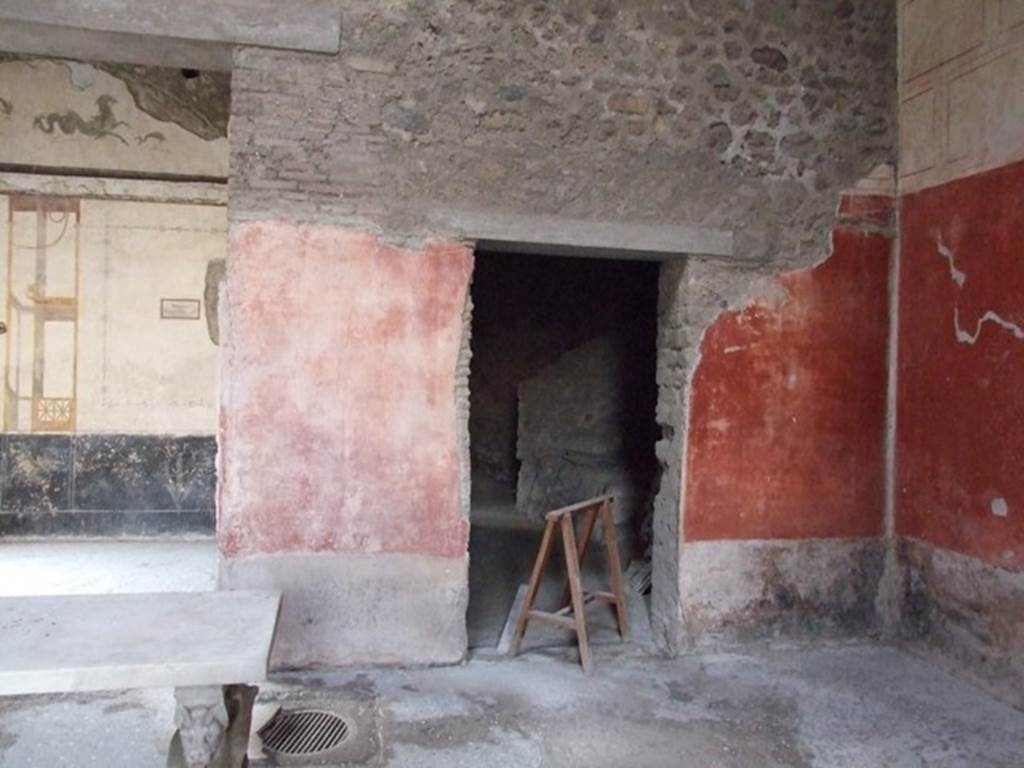 VI.15.8 Pompeii. December 2007.  West wall of the atrium and doorway to kitchen area, on right. At the foot of the dividing pillar between these two rooms, in the floor of the atrium, was the mouth of the cistern.
