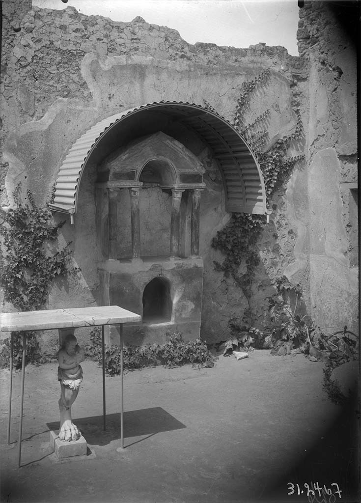 VI.15.8 Pompeii. 1931? Looking west across garden area towards household shrine.
In the foreground is a marble monopodium table
DAIR 31.2467. Photo © Deutsches Archäologisches Institut, Abteilung Rom, Arkiv. 
See Boyce G. K., 1937. Corpus of the Lararia of Pompeii. Rome: MAAR 14. (p.55, no.214, Pl.32,2).
