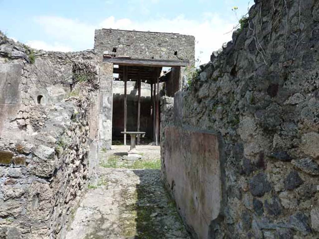 VI.16.28 Pompeii. May 2010. Looking east along fauces A, to atrium C. The floor was made of cocciopesto, in which was buried some pieces of marble without a design. The south wall preserved a high dado on a blackish background, finishing above with a wide red frieze.
Under the frieze was a simple coating of rough white plaster.  Found on the south wall, shown here on the right,  was a graffito MVSQ?N . Above on a coarse white plaster, in rather large letters was COPONII. From this graffito of Coponii, the house gained one of its names. See Notizie degli Scavi di Antichit, 1908, p. 271.
