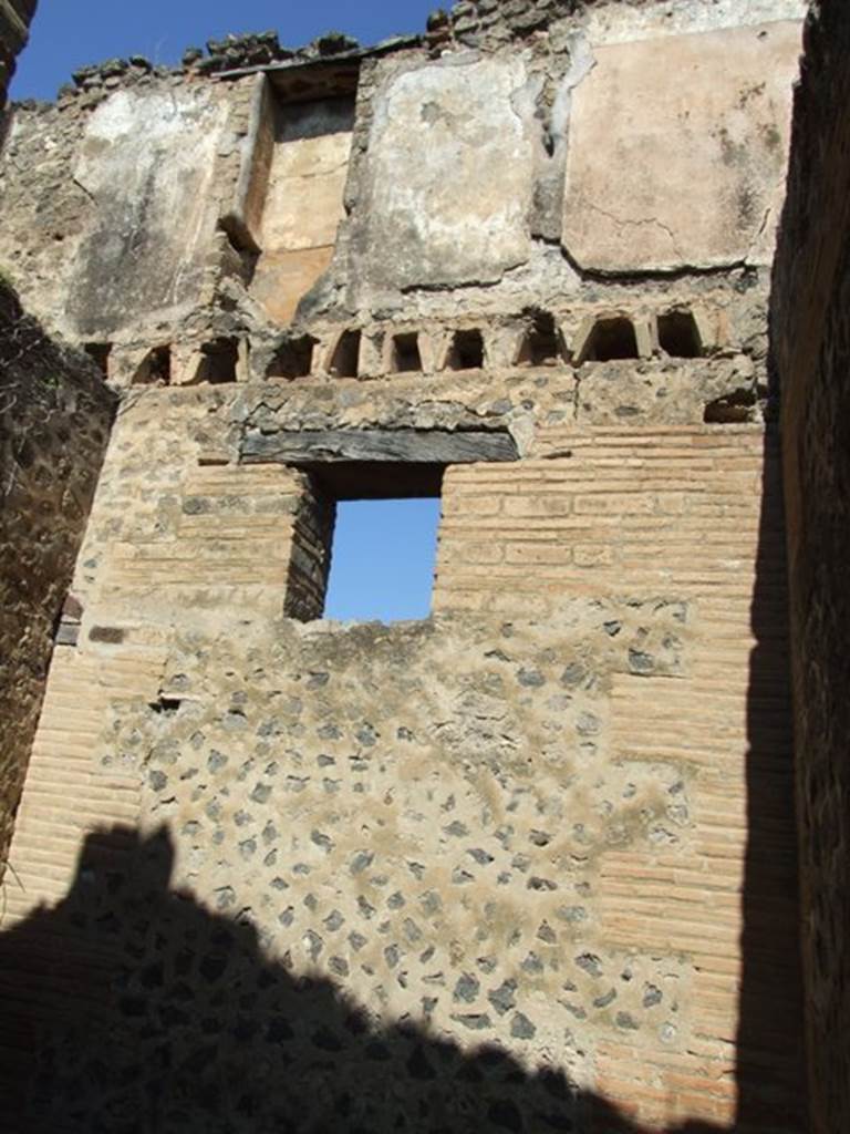 VII.2.18 Pompeii. March 2009. Room 9, north wall of cubiculum or porter’s room with window to Vicolo del Panettiere. The upper north wall would have been the upper floor and belonged to a separate apartment. The recess that can be seen would have been the latrine.
