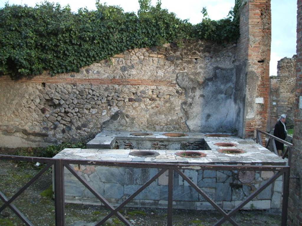 VII.2.32 Pompeii. December 2005. Entrance on Vicolo Storto. Looking  east towards the four-sided marble clad counter with seven urns. To the right is the entrance from VII.2.33 on Via degli Augustali.
