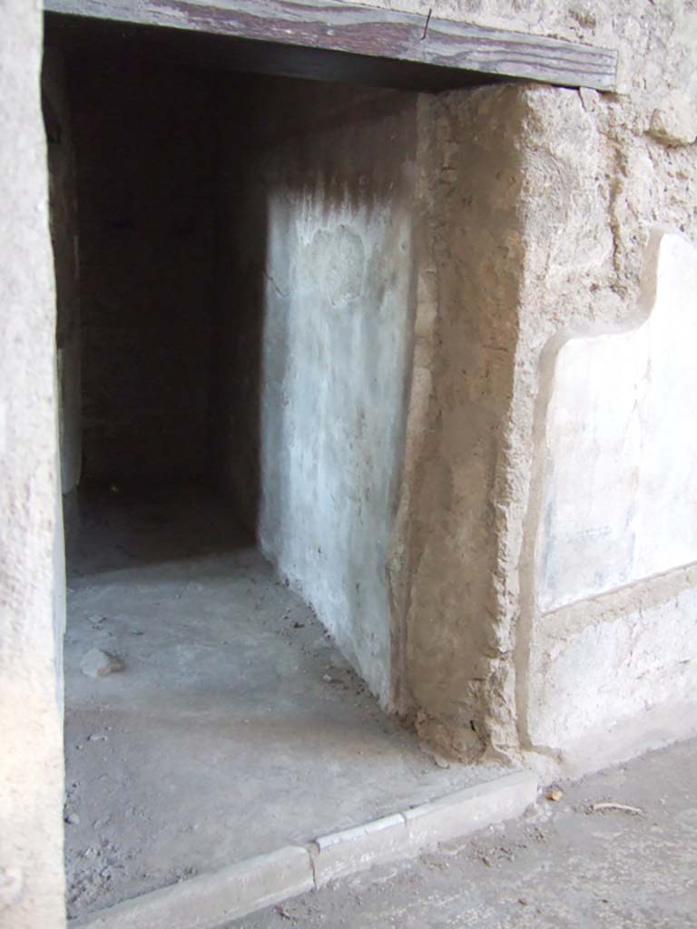 VII.2.45 Pompeii. September 2005. Doorway to first room on west side of atrium.
This is a narrow room with a further room on its south side with two high windows out on to the street.
According to Fiorelli, in the atrium of VII.2.45 on the left towards the doorway leading into VII.2.44, was the graffito, CIL IV 1679:
According to Della Corte, the graffito was found on the pilaster to the left of the room joining with the atrium of Colepio:  
Calos (H)edone.  Valeat qui legerit.  (H)edone dicit: Assibus (singulis) hic bibitur; dupundium si dederis, meliora bibes; qua(rtum) (assem) si dederis, vina Falerna bibes.    [CIL IV 1679]
See Della Corte, M., 1965. Case ed Abitanti di Pompei. Napoli: Fausto Fiorentino. (p. 180)

According to Epigraphik-Datenbank Clauss/Slaby (See www.manfredclauss.de) it read as:

Invicte castre(n)se 
habeas propiteos 
deos tu(c)<a=O>stresit 
e et qui leges 
calos (H)edone 
valeat qui legerit 
(H)edone dicit 
assibus hic 
bibitur dipundium 
si dederis meliora 
bibes quatt<u=O>s 
si dederis vina(m) 
Falerna(m) bib(es)     [CIL IV 1679]

According to the translation found in Pompeii, the history, life and art of the buried city, edited by Panetta, M. R, (page 231), this graffiti was found at the entrance to Hedone’s tavern:
Hedone says “You can get a drink here for only one coin. You can drink better wine for two coins. You can drink Falernian for four coins”. [CIL IV 1679]

According to Cooley, the graffito was found in the bar at VII.2.44, and gives the translation:
Hedone says, “You can drink here for one as, if you give two, you will drink better; if you give four, you will drink Falernian.”  [CIL IV 1679]
See Cooley, A. and M.G.L., 2004. Pompeii: A Sourcebook. London: Routledge. (p.162, H12).

