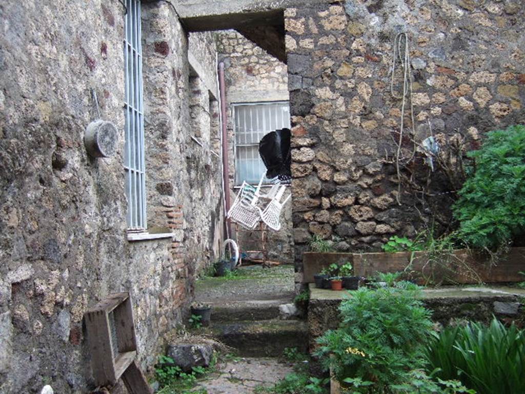 VII.3.24 Pompeii. Looking north from entrance.  According to Fiorelli, this was a workshop that was part of the house next-door.  This area had two furnaces, one basin and a hearth all mostly destroyed. The latrine was next to the entrance, together with a small room. Then, through the doorway with the two steps (possibly modern), was the atrium.
On the south side of the atrium were stairs to the upper floor, and on the north side was a cubiculum.
See Pappalardo, U., 2001. La Descrizione di Pompei per Giuseppe Fiorelli (1875). Napoli: Massa Editore. (p.87)



