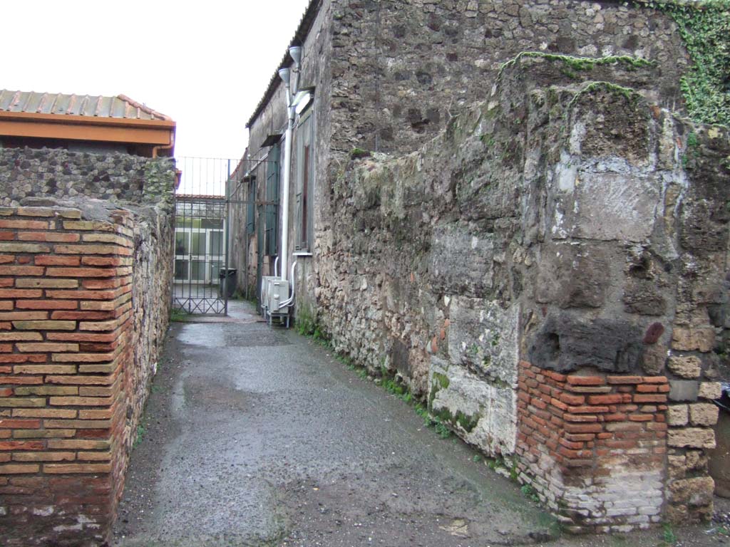 VII.4.8 Pompeii. December 2005. Looking east along passageway (modern reconstruction), a secondary exit for three houses.
In August 1823, graffiti were found on the pilaster between VII.4.7 and VII.4.8, on the left in this photograph. 
The graffiti, painted in red and black, read –

Casellium
aed(ilem)     [CIL IV 510]

<Q=O>(uintum)  Numisium     [CIL IV 511]

Maium aed(ilem) o(ro) v(os) f(aciatis)    [CIL IV 512]

Priscum    [CIL IV 513]

See Pagano, M. and Prisciandaro, R., 2006. Studio sulle provenienze degli oggetti rinvenuti negli scavi borbonici del regno di Napoli. Naples: Nicola Longobardi.  (p. 126)

