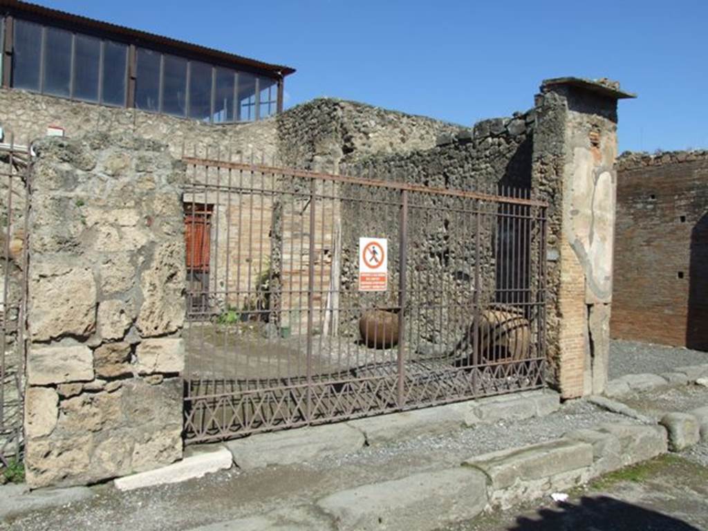 VII.4.22 Pompeii. March 2009. Entrance, looking towards east wall of shop-room.
According to Fiorelli, at the rear of this shop-room was the doorway to the atrium with a beautiful marble impluvium, puteal, and marble pedestal on which perhaps would have been a figure in relief throwing water into the basin below. To the left of the atrium, and behind shop no. 21, was a cubiculum, opposite the tablinum, the stairs to the upper floor, and nearby to this the triclinium, followed by the kitchen at the rear.
See Pappalardo, U., 2001. La Descrizione di Pompei per Giuseppe Fiorelli (1875). Napoli: Massa Editore. (p.90)
