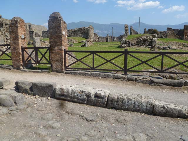 VII.6.7/6/5 Pompeii. May 2011. Entrance doorway to VII.6.7 (on left) and wider entrance to shop at VII.6.6 (centre). The thicker slab at the rear of the pavement (on the right) would be the base of the stairs to the upper floor at VII.6.5. Photo courtesy of Michael Binns.
