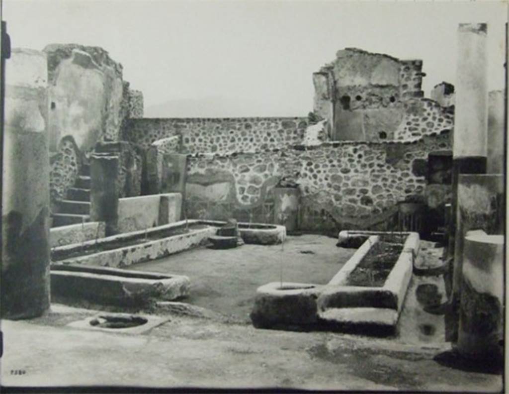 VII.6.7 Pompeii.  About 1910.  Peristyle garden.  
Looking south from north-west corner across two U-shaped masonry flower beds formed by low walls (0.26m. high), originally painted red and filled with soil.
According to Jashemski, the garden at the rear of the tablinum was enclosed on the east, north and west by a portico supported by 7 columns, red below and white above. All lacked capitals at the time of excavation. The rear (south) wall was divided into panels by engaged columns, similar to the columns of the portico. The columns were connected by a low wall, except for a wide entrance to the garden opposite the tablinum: the wall was lower in front of the large room (51) on the east (Jashemski’s plan numbered this room as (b). The panels appear to have been painted with garden paintings. A water channel outlined the garden. There was a cistern opening near the middle column on the north side. Spano found root cavities in the soil of the U-shaped masonry flower beds, but they were not emptied of lapilli, measured or studied. Twenty-eight cavities are indicated on his plan. In the south wall, near the south-east (?) corner of the peristyle was a square niche. 
On page 362, no.76, Jashemski wrote – at the time of excavation only the lower part of the rear (south) wall of the garden at the back of the house still had plaster, this was painted to represent a wooden fence (see also Jashemski, vol.1: fig.44 on page 30) which led Spano to believe that there had been a garden painting above. Nothing remains today, for this house was destroyed in 1943. 
See Jashemski, W. F., 1993. The Gardens of Pompeii, Volume II: Appendices. New York: Caratzas. (p.184) and (362, no.76).
Her sources included – Spano, Notizie degli Scavi, (1910) pp. 456-457; Boyce G. K., 1937. Corpus of the Lararia of Pompeii. (p. 67 no. 289)

The area was devastated in the 1943 bombing.  
The staircase on the east side is the only part still visible in situ.
At the rear of the staircase can be seen two small rooms, the latrine and the kitchen.
According to Boyce: the square niche on the south wall of the peristyle, near the south-west (?) corner, was coated with successive layers of stucco in red green and yellow.
See Boyce G. K., 1937. Corpus of the Lararia of Pompeii. Rome: MAAR 14.  (p.67. no.289).
Photograph courtesy of Soprintendenza Speciale per i Beni Archeologici di Napoli e Pompei. (Negative C359)


