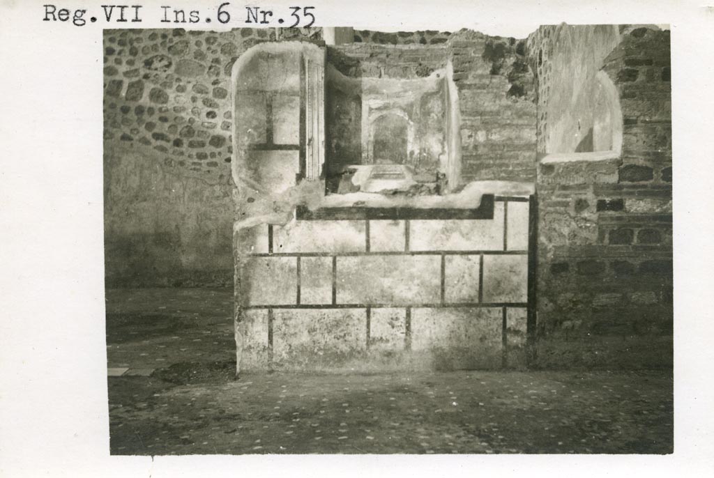 Mystery photo – Warsher numbered this as being from VII.6.35. We hope it is from -
VII.6.30 Pompeii. Pre-1937-39. Looking towards east wall of atrium, room 133/33, with room 139/39 on left.
Photo courtesy of American Academy in Rome, Photographic Archive. Warsher collection no. 560.
According to Boyce, in the east wall of the main room which was entered directly from the fauces was a delicately painted tall, rectangular niche.
He thought this was a Lararium. The white background of the surrounding wall was divided by dark stripes into a series of rectangles.
These rectangles were in imitation of a veneer of slabs of marble or of a wall built of rectangular blocks of stones.
See Boyce G. K., 1937. Corpus of the Lararia of Pompeii. Rome: MAAR 14. (p.67, no.292) 
According to the Notizie degli Scavi, 1910, page 481, in the east wall, to the right of the entrance doorway into room numbered 139, was a delicately painted niche, which served as a sacrarium. 
If anyone can confirm or refute this location, we would be pleased to hear from you.


