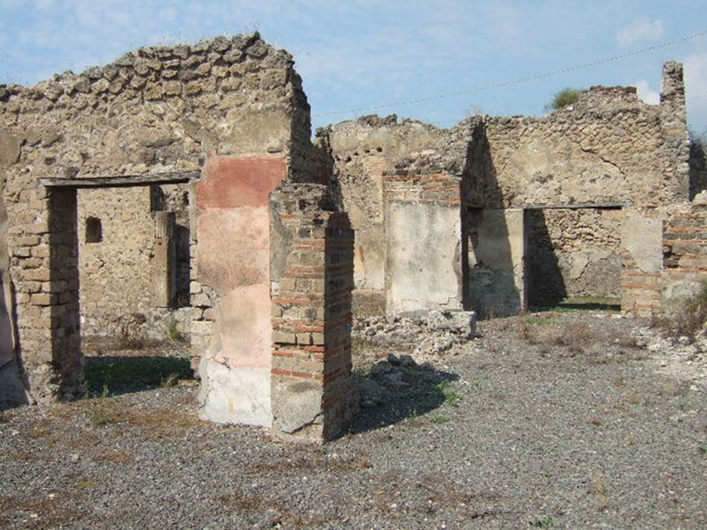 VII.6.30 Pompeii. September 2005.  Looking north-west across room with doorway to the garden, on left. On the right of the photo, the destroyed east wall would have contained a niche. According to Boyce, in the east wall of the main room which was entered directly from the fauces was a delicately painted tall, rectangular niche. He thought this was a Lararium. The white background of the surrounding wall was divided by dark stripes into a series of rectangles. These rectangles were in imitation of a veneer of slabs of marble or of a wall built of rectangular blocks of stones.
See Boyce G. K., 1937. Corpus of the Lararia of Pompeii. Rome: MAAR 14. (p.67, no.292) 
According to the Notizie degli Scavi, 1910, page 481, on the east wall …… a delicately painted niche, which served as a sacrarium. 
