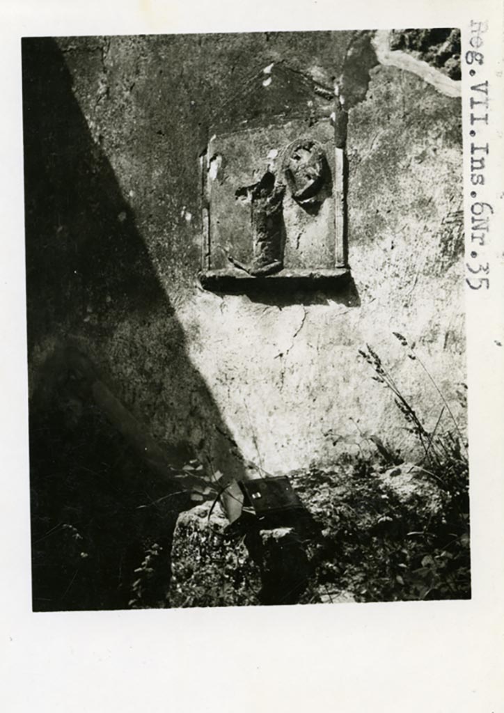 VII.6.35 Pompeii. Pre-1937-39. Lararium in stucco relief on west wall.
Photo courtesy of American Academy in Rome, Photographic Archive. Warsher collection no. 1906.
According to Boyce, on the west wall of the shop at VII.6.35 was a lararium entirely done in painted stucco.
Within an aedicula was a cylindrical altar in relief around which was coiled a serpent.
Near the serpent was the graffito – MARS   [CIL IV 1644] 
See Boyce G. K., 1937. Corpus of the Lararia of Pompeii. Rome: MAAR 14. (p.68, no.294, and Pl.28,3) 
