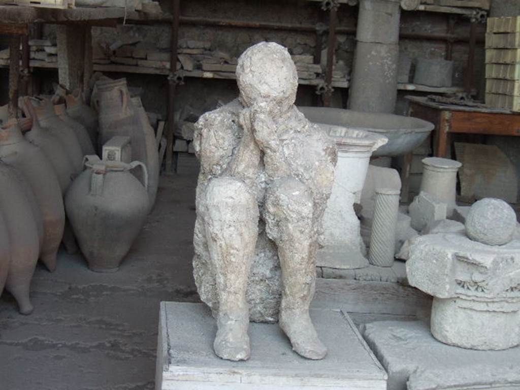 VII.7.29 Pompeii.  May 2006. Plaster cast of body and items in storage.