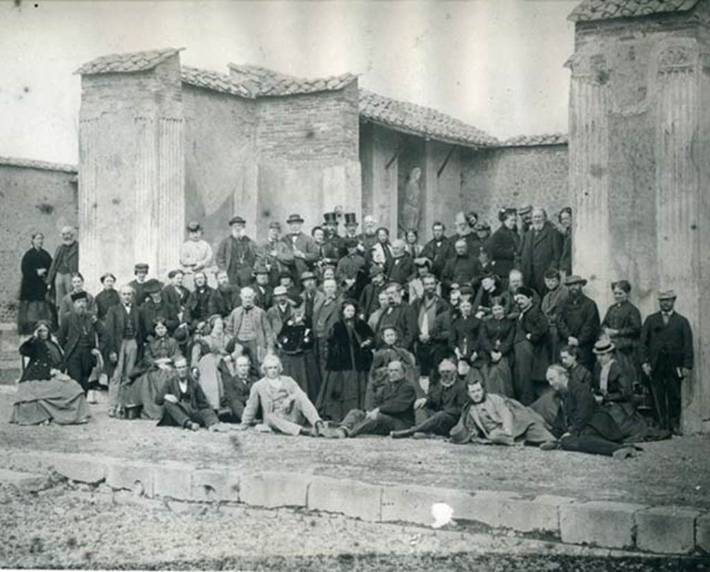 VII.9.7 and VII.9.8 Pompeii. Macellum. Thomas Cook’s party in 1868 in front of the shrine.
Thomas Cook himself sits upright in the centre of the front row, fourth from the right.
Photo courtesy of Rick Bauer. 
Our thanks to Paul Smith, Company Archivist at Thomas Cook UK & Ireland, for his assistance with this.
The original photo is in the Thomas Cook Archives now held in the Record Office for Leicestershire, Leicester and Rutland.
