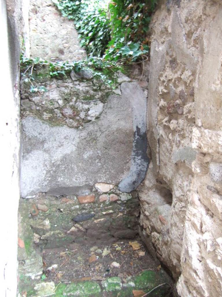 VII.13.8 Pompeii. December 2005. Latrine to east of rear entrance doorway VII.13.14. According to Hobson, a lead pipe may have delivered water to the latrine. See Hobson, B., 2009. Pompeii, Latrines and Down Pipes. BAR International series 2041. Oxford. Hadrian Books. (p. 409).