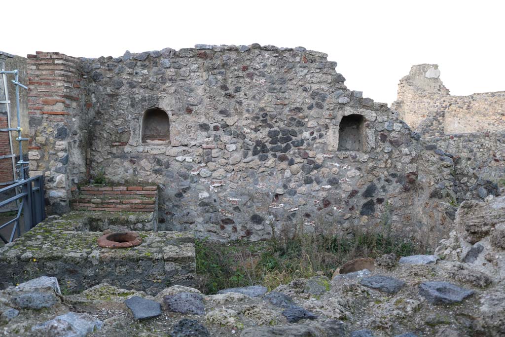 VII.16.7 Pompeii. December 2018.  
Looking west towards entrance doorway, on left, counter with display shelves and inset urn/s, and west wall with two niches.
Photo courtesy of Aude Durand.
