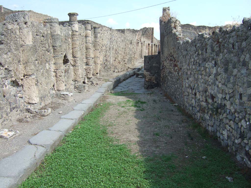 VII.16.17 Pompeii. September 2005. South perimeter wall on Vicolo dei Soprastanti, looking east. VII.15 is on right.