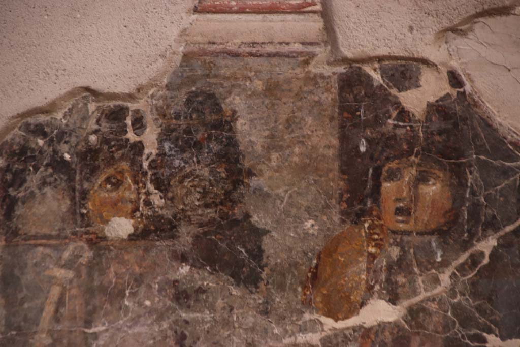 VII.16.a Pompeii. September 2021. Room 1, detail from painting of two masks on north wall.  Photo courtesy of Klaus Heese.