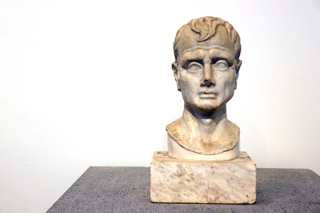 VIII.1.4 Pompeii. February 2021. Marble bust of a man, from VI.16.7. Photo courtesy of Fabien Bivre-Perrin (CC BY-NC-SA).
According to Maiuri, (p.106 above) 
displayed in the Room of Livia and of Pompeian Portraits, were two heads found in the House of the Golden Cupids at VI.16.7. 
One being a portrait which was originally supported by a wooden herm, and the other an idealized head. 
