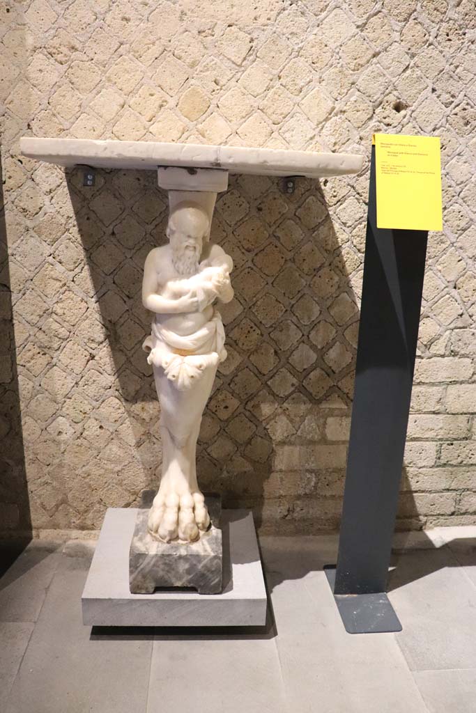 VIII.1.4 Pompeii Antiquarium. February 2021. 
Marble monopodium, with Silenus and Dionysus as a baby, found in VI.15.8.
Photo courtesy of Fabien Bivre-Perrin (CC BY-NC-SA).

