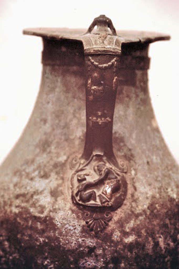 VIII.1.4 Pompeii Antiquarium. 1970. Detail of decorated bronze jug handle with figures and garlands.