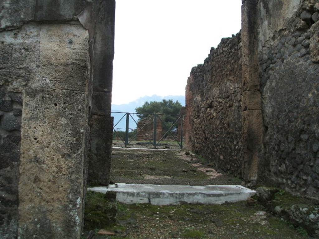 VIII.2.34 Pompeii. May 2006. Looking south across entrance corridor, from vestibule with remains of stone seat, on right. According to NdS, the entrance was preceded by a vestibule, a masonry seat was leaning against each side vestibule wall. There was one travertine step between the vestibule and the wide entrance corridor. Both the fauces and the vestibule sloped towards the roadway. The flooring of the fauces was made of opus signinum. See Notizie degli Scavi, 1885, (p.163)
