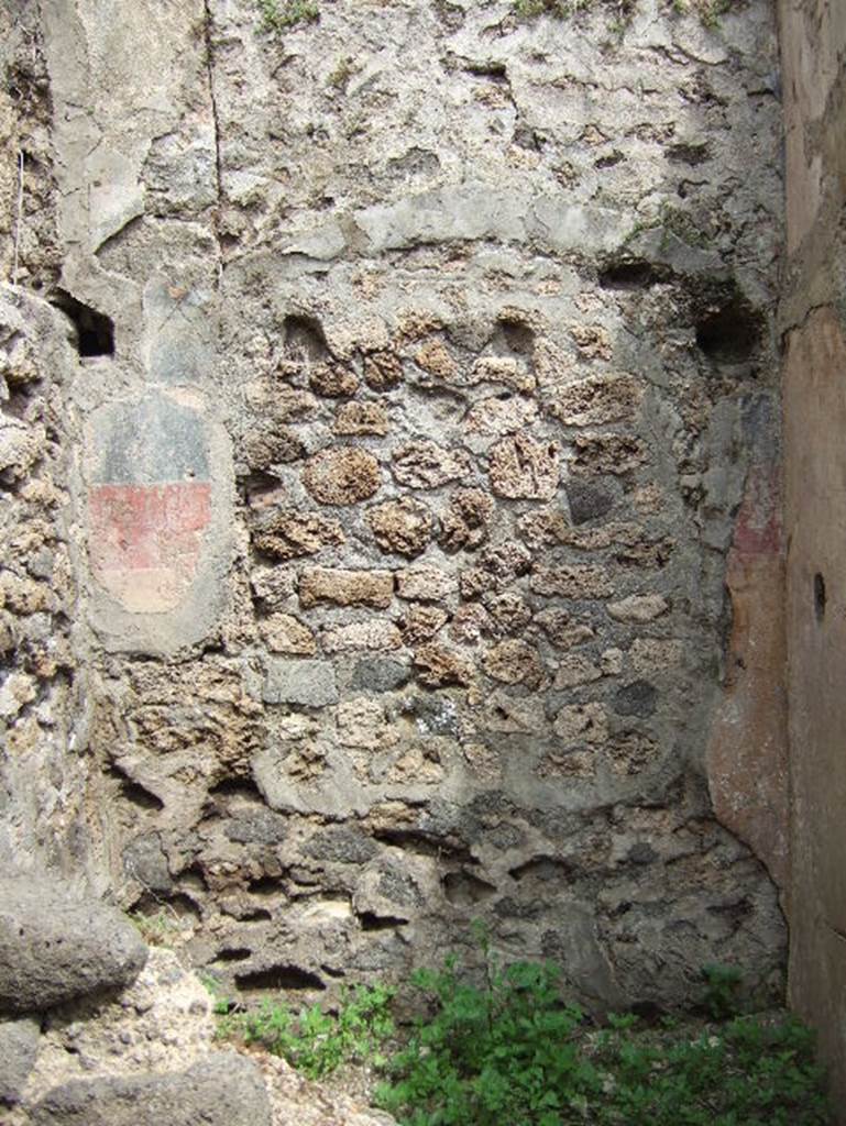 VIII.2.34 Pompeii. May 2006. Room ‘1’, north wall of cubiculum of lower rear room, painted with a high yellow zoccolo, separated from the black painted middle zone by a red line. 
Above were the remains of the holes for the beams for the support of a wooden mezzanine.
At the north end of the west wall, the recess for the bed could be seen on the higher level (top left of photo).