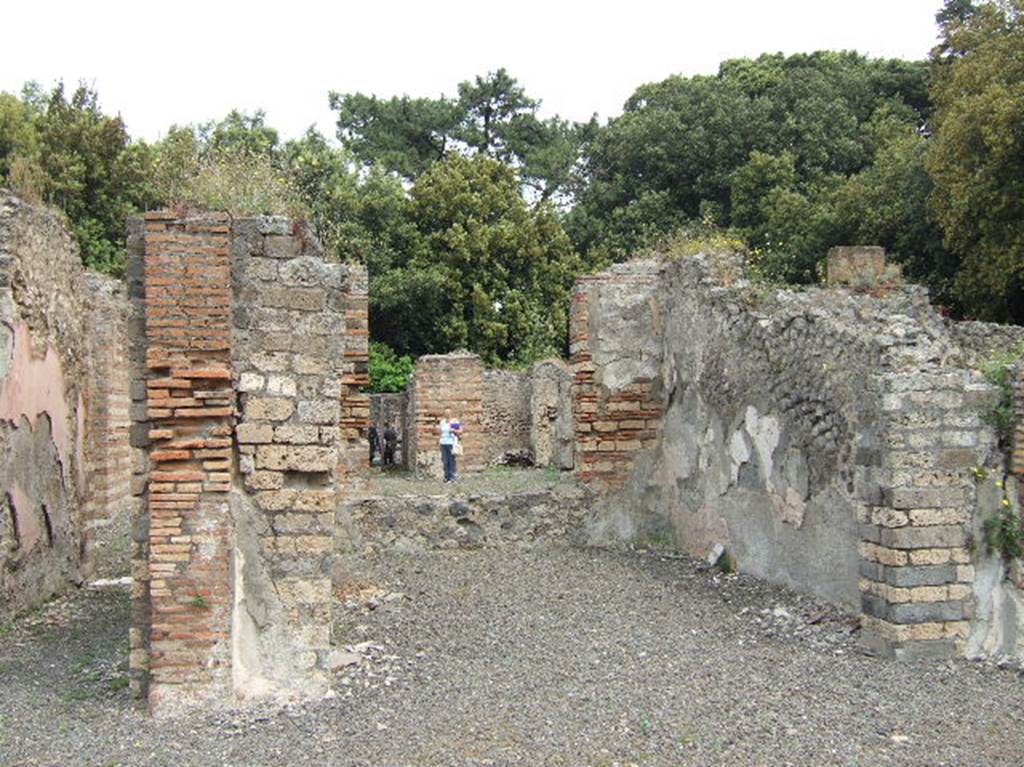 VIII.2.39 Pompeii. May 2006. Room r, tablinum, from large room, w.  
Looking north across tablinum, towards atrium and entrance doorway.
According to Jashemski, all of the rooms at the rear of this house were built out over the south wall of the city. At the rear on the street level, the large room w, and the triclinia on either side of it (rooms v and x) were completely open onto the portico that preceded the terrace.
See Jashemski, W. F., 1993. The Gardens of Pompeii, Volume II: Appendices. New York: Caratzas. (p.209 and fig 244, reconstruction of rear of house).
