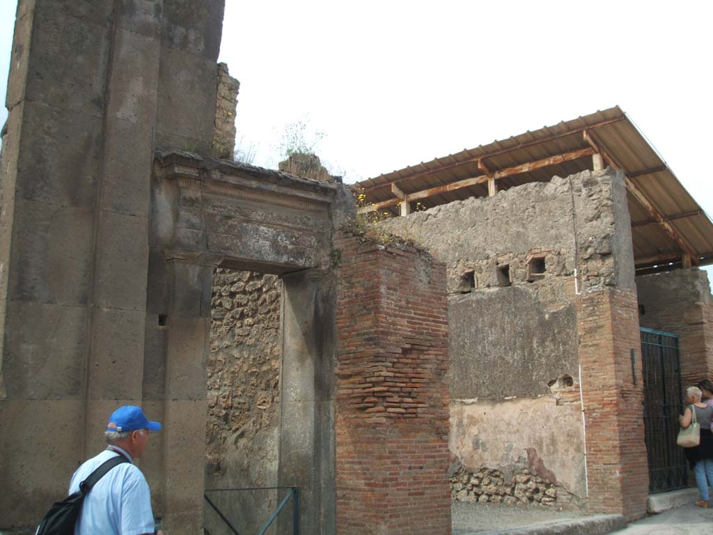 VIII.3.10 and VIII.3.9 Pompeii. September 2004. Looking south-west on Via dell’Abbondanza.
According to Della Corte, he thought the seat of the Collegium Aurificum may have been on the upper floor of VIII.3.9.
He deduced this by an electoral recommendation, mutual to all the neighbours, that was on the opposite external wall of the Building of Eumachia. 
This read -
Aurifices universi rog(ant)  [CIL IV 710]
From this graffito, Della Corte states the name of the “Via degli Orefici” was given to the street in some of the old bibliographies.
See Della Corte, M., 1965. Case ed Abitanti di Pompei. Napoli: Fausto Fiorentino. (p.229)

According to Epigraphik-Datenbank Clauss/Slaby (See www.manfredclauss.de) the graffito read as -

C(aium)  Cuspium  Pansam  aed(ilem) 
aurifices  universi 
rog(ant)         [CIL IV 710] 
