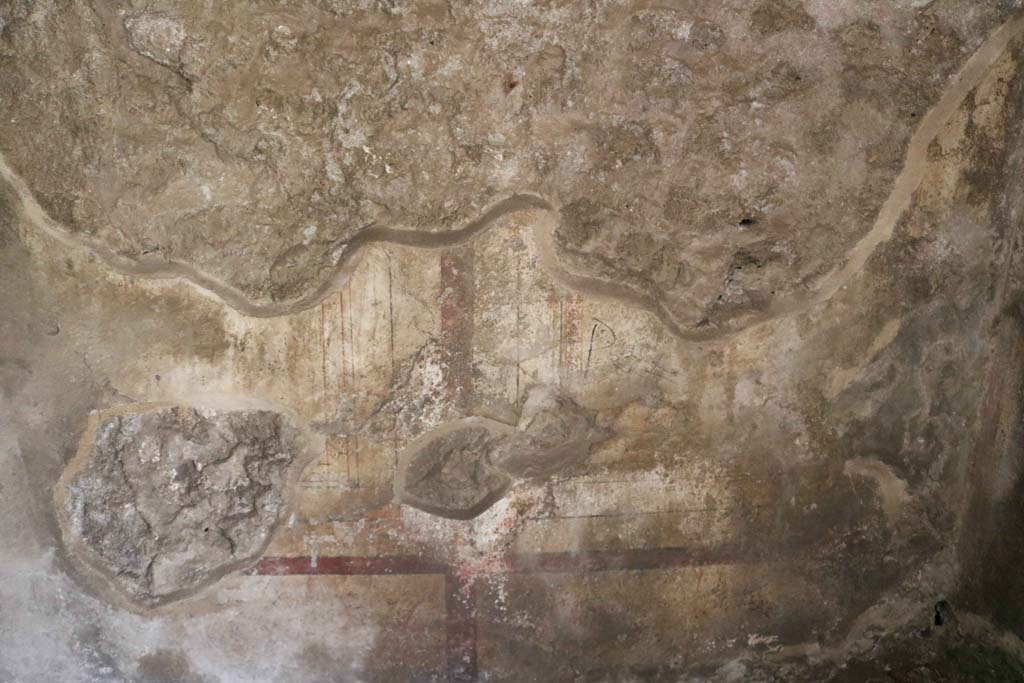 VIII.3.11, Pompeii. December 2018.  
Looking towards painted decoration at base of vaulted west wall of cubiculum. Photo courtesy of Aude Durand.
According to PPM – the west wall was decorated with zoccolo and middle zone of wall in white by red lines and bands. 
See Carratelli, G. P., 1990-2003. Pompei: Pitture e Mosaici. (8). Roma: Istituto della enciclopedia italiana, (p.393, no.14.)
