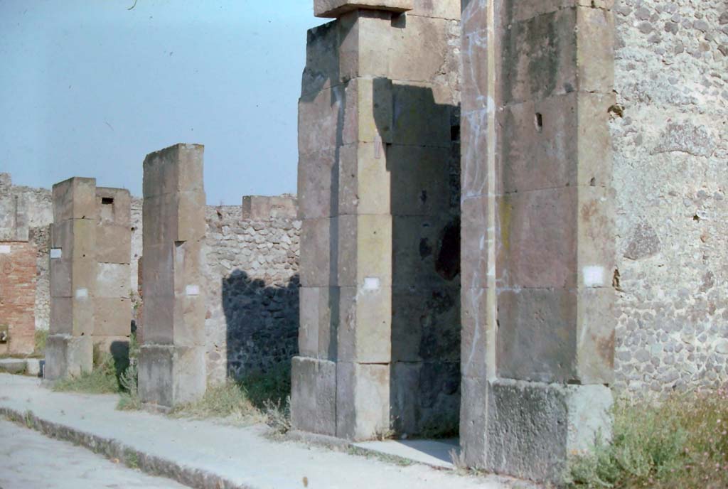VIII.5.28 Pompeii. 7th August 1976. 
Looking south-east along south side of Via dell’Abbondanza, with Via dei Teatri, on left, followed by VIII.5.30/29/28 and 27, on right.
Photo courtesy of Rick Bauer, from Dr George Fay’s slides collection.
According to Bonucci, 
Casa di Fusco – 1819 - Before arriving to the Piazza del Teatro you pass by an infinite number of shops, which attest trade, and the riches of this city. Among them we can recognize, from their exhibition, those where the mosaicists worked. The fountains with beautiful quadrangular marble basins are abundant in this street. Their abundance, and that of wells, reservoirs, and cisterns, as well as the universal use of baths, public and private gardens, and galleries open to the sea attest to the great heat which suffer on this volcanic hill, and the well-understood measures taken to guarantee it. On this street a glass vase with whole eggs was found; and 939 bronze coins.

Fusco's house has a beautiful Gynaeceum, mosaics, and the varied and ingenious decorations in the capricious taste of a stage performer. Fish are depicted in the dining room, and love scenes in the bedroom. Not a few bronze, glass, and terracotta vases were found; two gold pendants, and a piece of pitch, which after so many centuries still retains the smell of that substance.

See Bonucci, C., 1827. Pompei Descritta: Terza Ed. Napoli: Miranda, p. 177.
