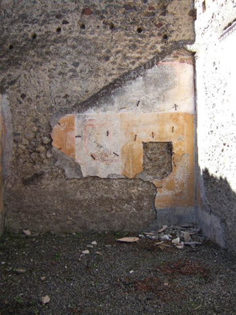 VIII.5.39 Pompeii. September 2005. Room 5, west wall.
According to PPM – The IV Style decoration is better preserved on this wall.
The central panel was white, the side panels were yellow edged with a border of “carpet” design; 
the one on the right (north end) contained a medallion showing the head of a young girl – now taken off
The zoccolo would have been black with painted plants.
See Carratelli, G. P., 1990-2003. Pompei: Pitture e Mosaici: Vol. VIII. Roma: Istituto della enciclopedia italiana, p. 659.
