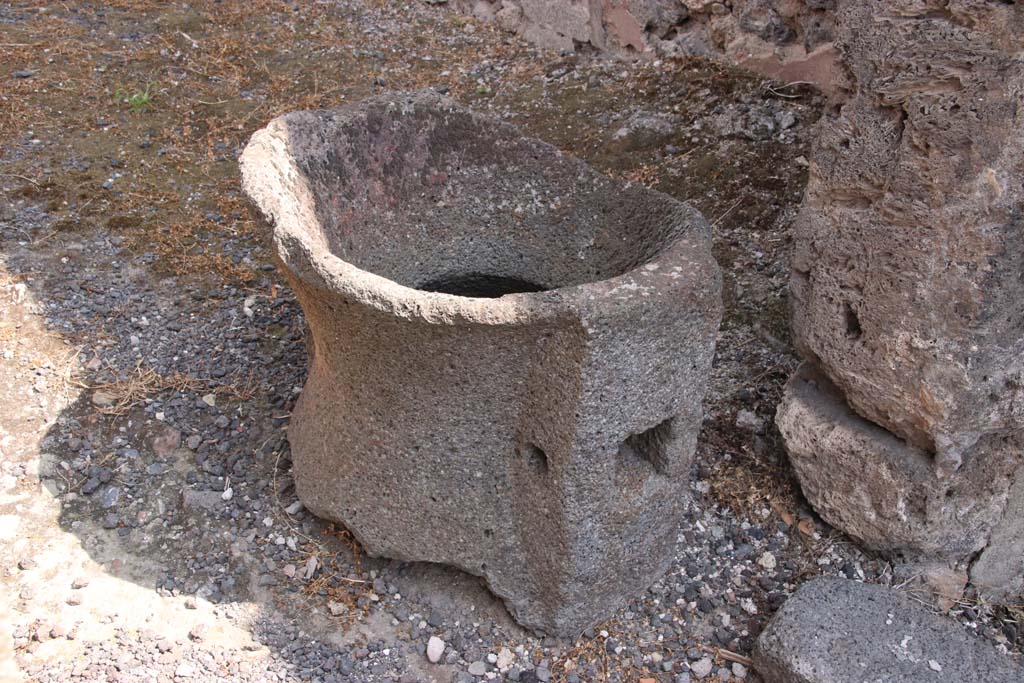 IX.2.4 Pompeii. September 2021. 
Fragment of mill (catillus) near entrance to shop, in south-west corner. Photo courtesy of Klaus Heese.
