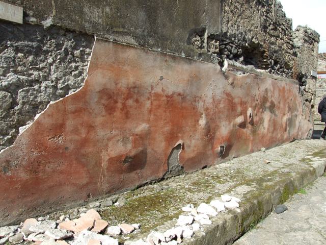 IX.2.16 Pompeii. March 2009.  Painted plaster on outside wall, bulging and falling onto the pavement. Looking east.
