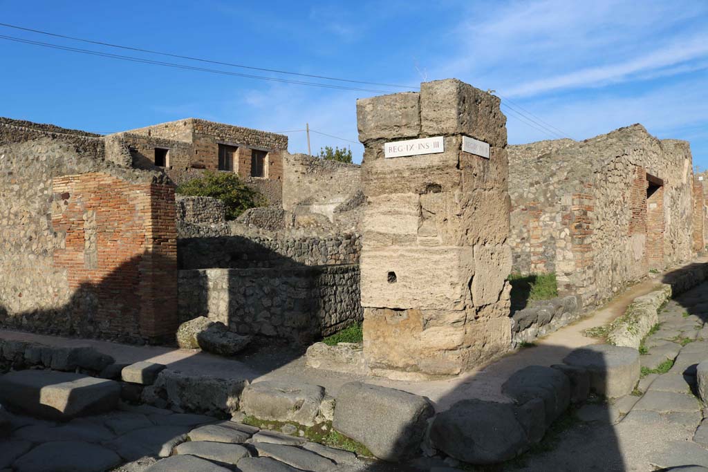 IX.3.10, centre left, and IX.3.11, centre right, Pompeii. December 2018. 
Looking north-east towards corner of junction between Via Stabiana, on left, and Vicolo, on right. Photo courtesy of Aude Durand.


