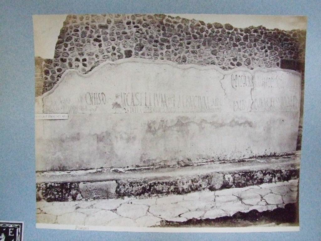 IX.3.19 Taberna T. Genialis.  Graffiti on wall between IX.3.18 and IX.3.19.  Old undated photograph courtesy of the Society of Antiquaries, Fox Collection.
