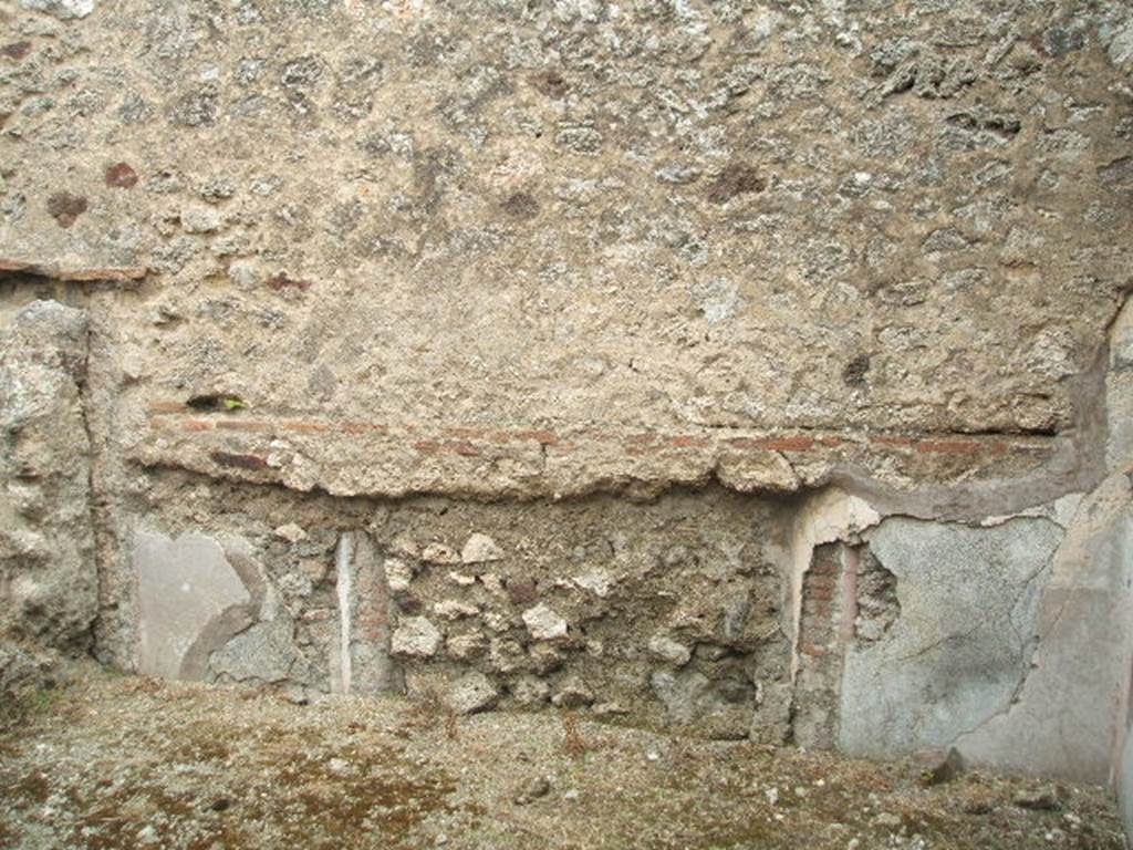 IX.3.23 Pompeii. May 2005. East wall with a blocked doorway, in room in south-east corner of atrium.  According to Fiorelli, this would have been a dormitory, with capacity for a few beds. The plinth/zoccolo was red, the middle zone of the wall was white ?. On the half-columns which decorated the doorposts were the remains of painted faux marble.
See also Bragantini, de Vos, Badoni, 1986. Pitture e Pavimenti di Pompei, Parte 3. Rome: ICCD. (p.450)
