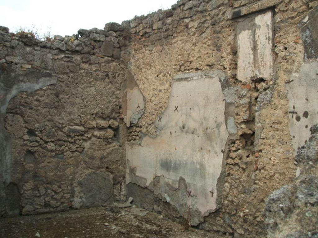 IX.3.23 Pompeii. May 2005. North-west corner of triclinium, on west side of entrance corridor. In the north wall is a blocked window overlooking the small vicolo. In this room remains of cocciopesto flooring can be seen.
