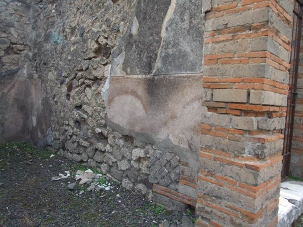 IX.5.7 Pompeii. December 2007. West wall of shop with high cocciopesto zoccolo with white walls above.

