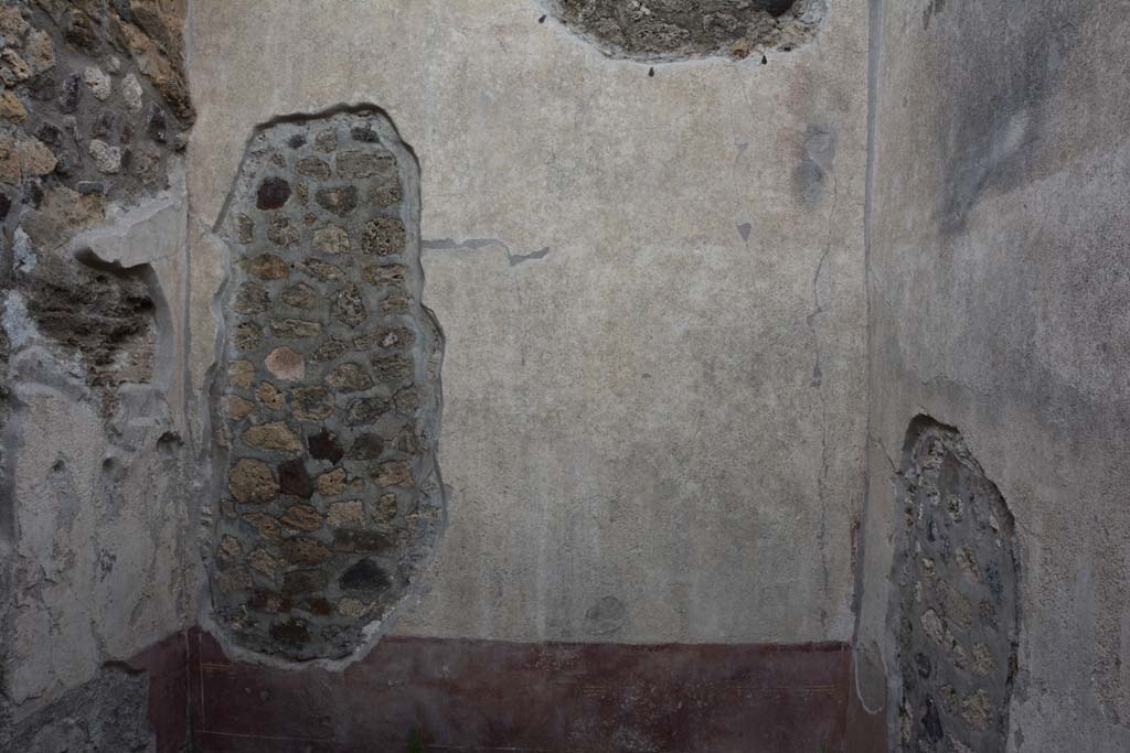 IX.5.9 Pompeii. March 2017. 
Room “f”, looking towards east wall with a large hole which would have been made by the ancient searchers of the house.
The walls of this room would have had a red zoccolo, showing painted plants in panels edged with “carpet borders”. The middle zone was painted white, divided into two panels by a central compartment with a painted candelabra.
In the panel on the right (south side) was a painting of masks crowned with foliage.
Foto Christian Beck, ERC Grant 681269 DÉCOR.



